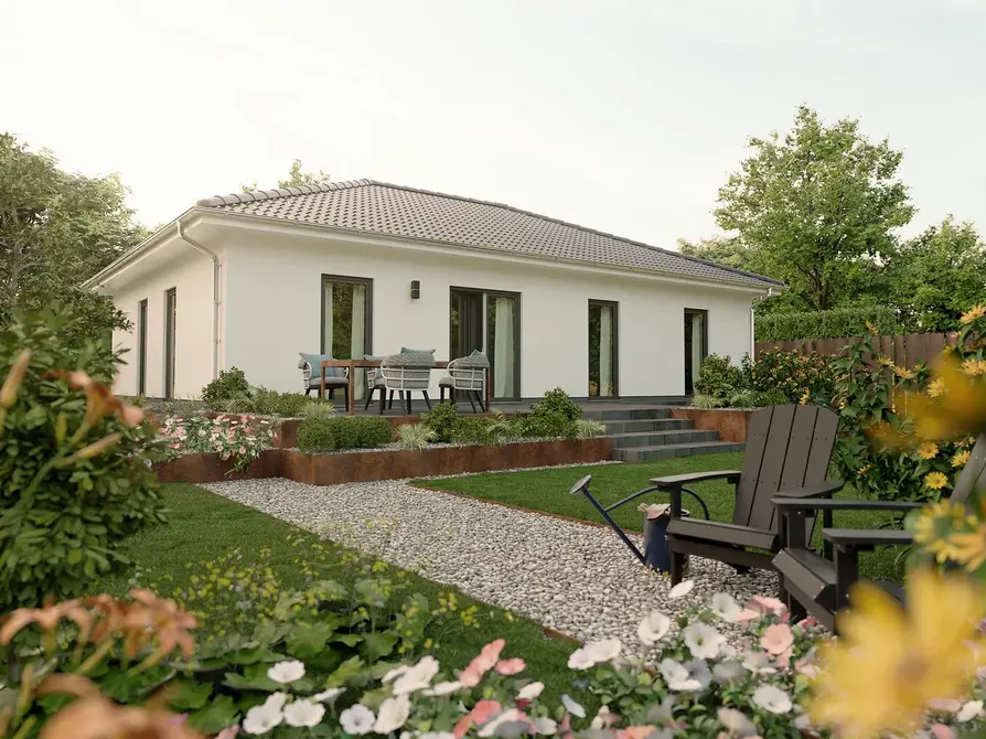 Klassischer Bungalow 110 von Town & Country Haus mit gepflegtem Gartenweg, farbenfrohen Blumen und bodentiefer Fensterfront